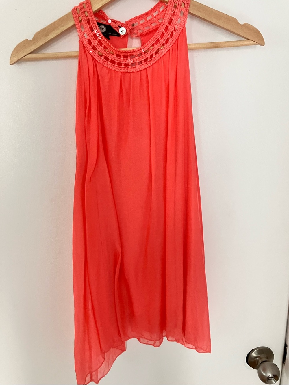 Coral silk top with sequins embellishment around neckline.